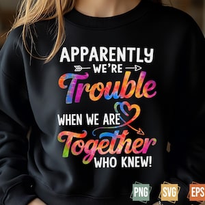 May include: Black sweatshirt with a colourful tie-dye design. The text on the sweatshirt reads "Apparently we're trouble when we are together who knew!"