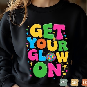May include: Black sweatshirt with the phrase "GET YOUR GLOW ON" in colorful, bubble letters. A disco ball graphic is featured in the design. The sweatshirt is a crew neck style.