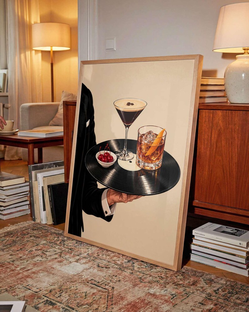 Pode incluir: Uma impress&atilde;o de arte emoldurada apresentando um disco de vinil preto usado como bandeja. O disco sustenta uma ta&ccedil;a de martini com gr&atilde;os de caf&eacute;, um copo com casca de laranja e uma pequena tigela branca cheia de cerejas vermelhas brilhantes.