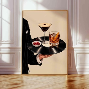 Pode incluir: Uma impress&atilde;o de arte de parede emoldurada retratando uma pessoa de palet&oacute; preto segurando um disco de vinil preto como bandeja. No disco, h&aacute; uma ta&ccedil;a de martini com gr&atilde;os de caf&eacute;, um copo de u&iacute;sque com casca de laranja e cerejas vermelhas.