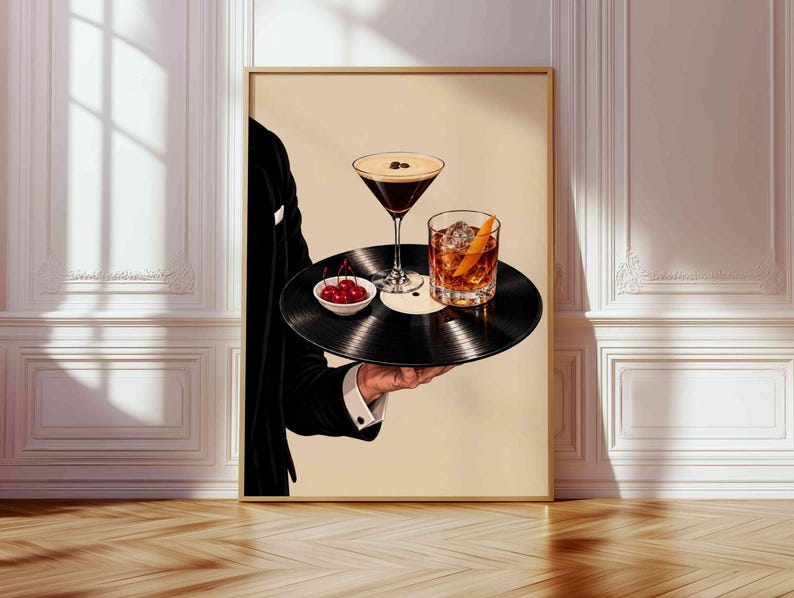 Pode incluir: Uma impress&atilde;o de arte de parede emoldurada retratando uma pessoa de palet&oacute; preto segurando um disco de vinil preto como bandeja. No disco, h&aacute; uma ta&ccedil;a de martini com gr&atilde;os de caf&eacute;, um copo de u&iacute;sque com casca de laranja e cerejas vermelhas.