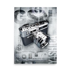 May include: A silver and black Yashica Electro 35 rangefinder camera with a prominent lens, set against a grey background featuring the text GSN and ELECTRO 35. The camera body displays metallic dials, a shutter button, and a lens barrel.