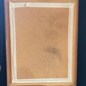 May include: A wooden picture frame with a brown cardboard backing. The frame has a white tape border around the edge.