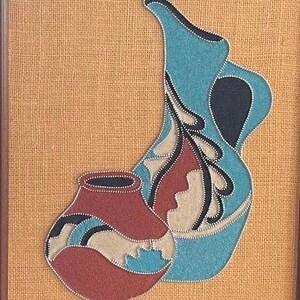 May include: Two pottery vessels, one blue and one red, with intricate designs, are displayed against a burlap background.