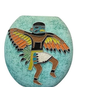May include: A turquoise ceramic vase with a textured surface. The vase features a detailed, colourful depiction of a Native American dancer with outstretched wings. The dancer is adorned in traditional attire with brown, black, yellow, orange, and white accents.