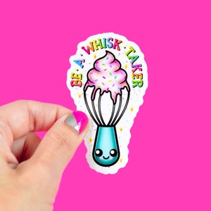 Könnte beinhalten: Ein weißer Aufkleber mit einem Cartoon-Schneebesen mit rosa Zuckerguss und Streuseln. Der Text "Be a Whisk Taker" ist in Regenbogenfarben um den Schneebesen geschrieben.