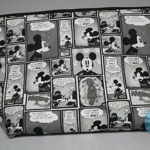 May include: A black and white zippered pouch with a repeating pattern of Mickey Mouse comic book panels. The panels feature Mickey Mouse in various poses and expressions, with text bubbles that say "You're not the boss of me!" and "Oh gosh, I couldn't live on that!"