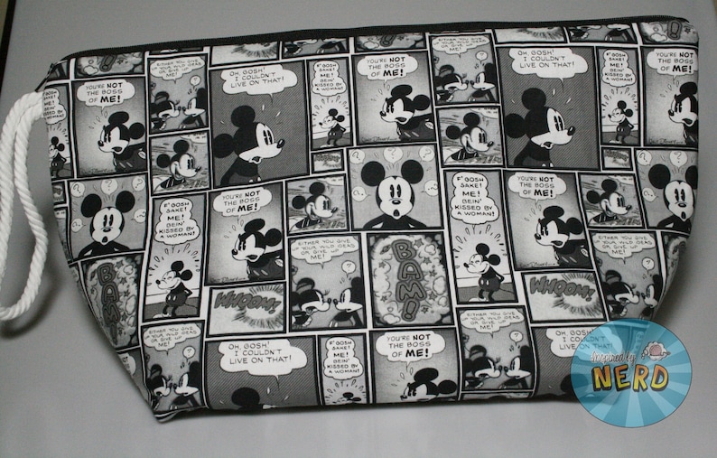 May include: A black and white zippered pouch with a repeating pattern of Mickey Mouse comic book panels. The panels feature Mickey Mouse in various poses and expressions, with text bubbles that say "You're not the boss of me!" and "Oh gosh, I couldn't live on that!"