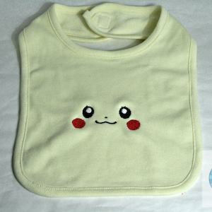 K&ouml;nnte beinhalten: Ein hellgelber Baby-L&auml;tzchen mit einem gestickten Pikachu-Gesicht. Das Gesicht hat schwarze Augen, eine rote Nase und ein kleines L&auml;cheln.