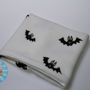 May include: White socks with a black bat pattern. The socks are folded and show the pattern on the front and back.