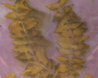 May include: A wreath-like arrangement of yellow leaves on a pink background. The leaves are arranged in a semi-circular shape, with some individual leaves scattered around the edges. The leaves have a delicate, textured appearance.