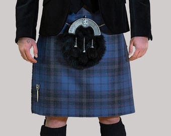 May include: A blue tartan kilt with black and red accents, worn with a black jacket and vest. The kilt features a sporran, a traditional Scottish accessory, and a kilt pin. The outfit is completed with black socks.