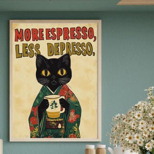 May include: A framed art print featuring a black cat wearing a kimono and holding a coffee cup. The print has the text "MORE ESPRESSO, LESS DEPRESSO" in red and yellow. The background is a light beige color.
