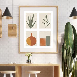 May include: A framed print with a minimalist design featuring four squares. Each square contains a simple illustration of a plant or geometric shape in shades of green, orange, and brown. The print is hanging on a white brick wall.
