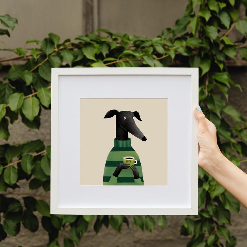 May include: A framed art print featuring a stylized greyhound dog wearing a green and white striped sweater. The dog is holding a green mug with a brown liquid. The background is a light beige color.