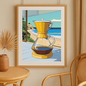 May include: A framed art print depicts a yellow coffee pour-over set with a glass carafe filled with dark liquid. The background shows a beach scene with blue water and a sandy shore. The artwork is in a pop art style.