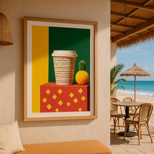 May include: A framed art print featuring a coffee cup with a geometric pattern, a small cactus, and an orange sphere on a red block. The background is divided into yellow and green sections. The scene is set near a beach.