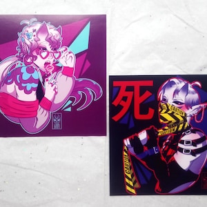 May include: Two square prints featuring colorful illustrations of characters. The first print features a pink character with blue and pink hair, wearing pink heart-shaped glasses and a pink and blue sweater. The second print features a white character with blue hair, wearing a black and yellow caution tape mask and a black outfit.