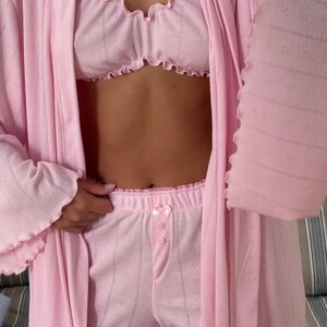 May include: A set of three ceramic mugs with a speckled, matte finish. The mugs are in shades of cream, light gray, and dark gray. Each mug has a simple, minimalist design and a rounded handle. The mugs are stacked on top of each other.