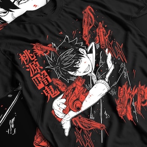 Puede incluir: Camiseta negra con una ilustración de estilo manga de un personaje sosteniendo una pistola roja, con gráficos de pistolas rojas adicionales. Texto japonés impreso en el lado izquierdo de la camiseta. El personaje tiene cabello negro y un atuendo blanco y negro.