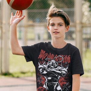 May include: Black t-shirt featuring a graphic of a character from the anime series Fullmetal Alchemist, with Japanese text in red. A red and white basketball is being spun on a finger.
