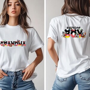 May include: White t-shirt with a graphic of the word "Grandma" made up of Disney characters. The back of the shirt has a graphic of the word "Birthday Boy" made up of Disney characters.