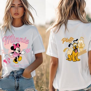 K&ouml;nnte beinhalten: Wei&szlig;es T-Shirt mit Minnie Mouse in rosa Kleid und Schleife, sowie dem Schriftzug "Minnie". Auf der R&uuml;ckseite Pluto mit der Aufschrift "Pluto 1930". Das Design ist rosa und gelb.