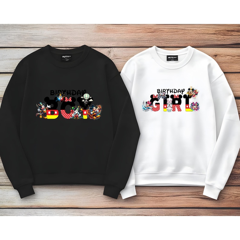 May include: Two black and white sweatshirts with a Mickey Mouse theme. The black sweatshirt has the text "Birthday Boy" with Mickey Mouse characters forming the letters. The white sweatshirt has the text "Birthday Girl" with Mickey Mouse characters forming the letters.