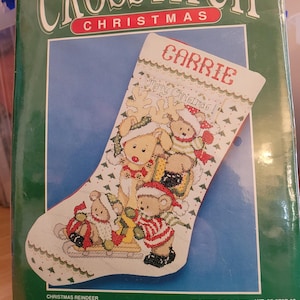 以下が含まれることがあります： Bernatのクリスマス用クロスステッチキット。パッケージにはCarrieという名前、トナカイ、テディベアが描かれた靴下のデザインが印刷されています。パッケージには完成サイズが22.86cm x 40.64cmと記載されており、14カウントのアイーダ布が含まれています。