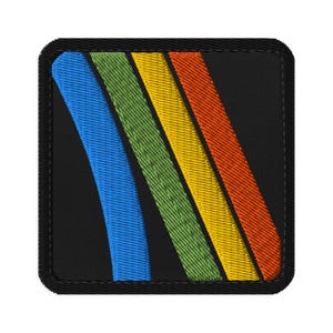 May include: Embroidered patch with a black background and a square shape. The design features four diagonal stripes in blue, green, yellow, and orange. The patch has a black border.