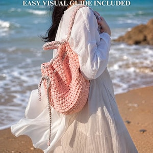 May include: A handmade, pink crochet backpack with gray accents. The bag has a drawstring closure and thick straps. The text "EASY VISUAL GUIDE INCLUDED" is at the top of the image. The bag is shown on a beach.