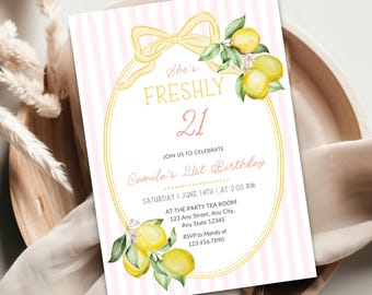 May include: A rectangular birthday invitation card featuring a light pink and white vertical striped background. The center displays a yellow oval frame with a bow, yellow lemons with green leaves, and text reading She's FRESHLY 21.