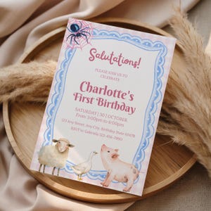 May include: A rectangular birthday invitation card featuring a pink and white gingham background with a blue scalloped border. The text reads Salutations! PLEASE JOIN US TO CELEBRATE Charlotte's First Birthday SATURDAY 30 OCTOBER. Includes illustrations of a spider on a web, a sheep, a goose, and a pig.