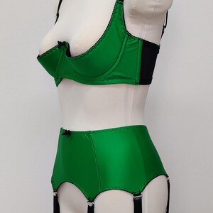 emerald green quarter cup bra with black straps, trim and bow, shown with matching Greta garter belt, side view