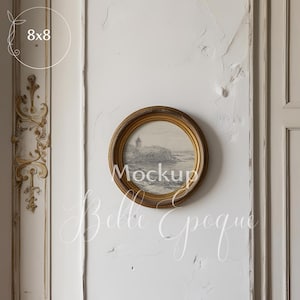 May include: A gold-framed oval picture with a black and white seascape image hangs on a white wall with ornate molding. The text "Mockup" is visible in the image.
