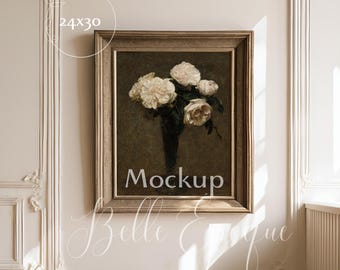 May include: A framed painting featuring a still life of white roses in a dark vase. The artwork is set against a dark background and is enclosed in a gold-toned frame. The dimensions are 24x30 inches. The word "Mockup" is visible.