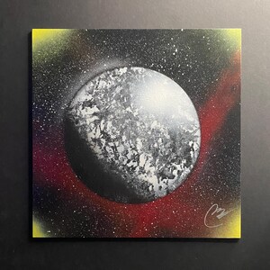 May include: A black and white planet with a textured surface, set against a dark background with red and yellow accents. The planet appears to be in space with a starry background.