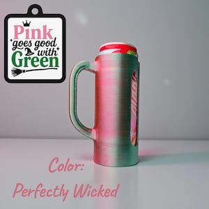 May include: A green and pink mug with a handle, holding a can. The mug has a clear window showing the can's design. A sign with the text "Pink goes good with Green" hangs nearby. The color is "Perfectly Wicked."