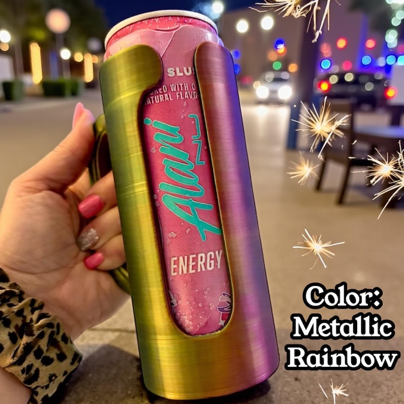 May include: A metallic rainbow-colored can cooler holding a pink Alani Nu Energy drink can. The can has teal lettering and the cooler has a handle. The text "Color: Metallic Rainbow" is in the bottom right corner.