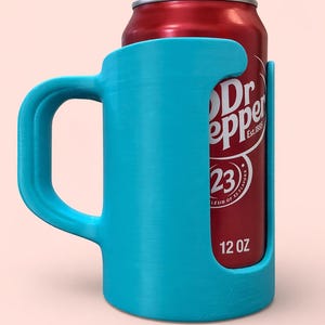May include: A bright turquoise can holder with a handle, designed to hold a standard 12 oz can. The holder is made of a solid material and features a cutout to display the can's label. A red Dr Pepper can is visible.