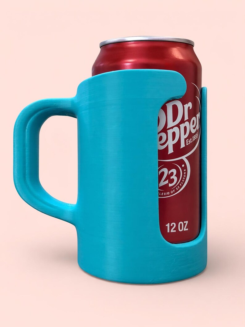 May include: A bright turquoise can holder with a handle, designed to hold a standard 12 oz can. The holder is made of a solid material and features a cutout to display the can's label. A red Dr Pepper can is visible.
