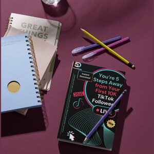 May include: A selection of notebooks, pens, and pencils on a deep purple surface. One notebook is light blue with a gold circle, and another has the words "GREAT THINGS" on the cover. A book with the text "You're 5 Steps Away from Your First 10K TikTok Follower" is also present.