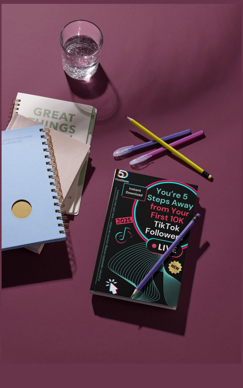 May include: A selection of notebooks, pens, and pencils on a deep purple surface. One notebook is light blue with a gold circle, and another has the words "GREAT THINGS" on the cover. A book with the text "You're 5 Steps Away from Your First 10K TikTok Follower" is also present.