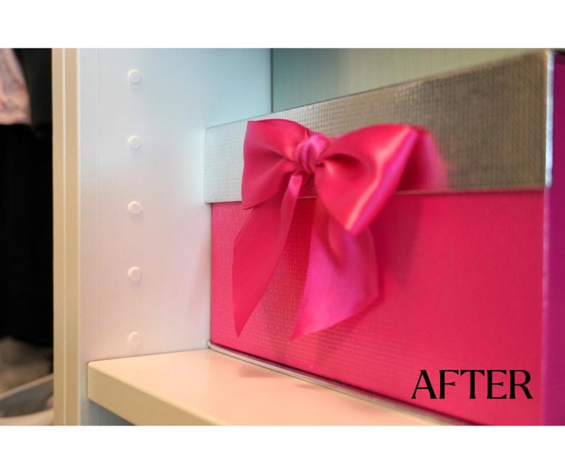 K&ouml;nnte beinhalten: Eine leuchtend pinkfarbene Geschenkbox mit silbernem Deckel und einer gro&szlig;en, passenden pinkfarbenen Satinschleife. Die Box steht auf einem wei&szlig;en Regal, mit dem Wort "AFTER" auf der Vorderseite.