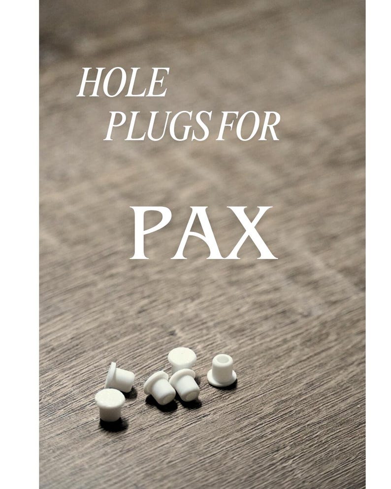 K&ouml;nnte beinhalten: Wei&szlig;e Lochstopfen f&uuml;r PAX werden auf einer Holzoberfl&auml;che gezeigt. Der Text "HOLE PLUGS FOR PAX" ist wei&szlig; gedruckt. Die Stopfen sind klein, zylindrisch und haben eine flache Oberseite.