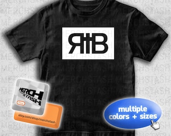 May include: Black t-shirt with a white rectangular graphic featuring the letters "ЯTB" in a bold, stylized font. The image also includes a shop logo and a button that says "multiple colors + sizes".
