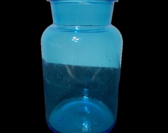 May include: A vintage blue glass bottle with a wide mouth and a rounded bottom. The bottle is clear and has a textured surface.