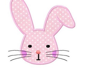 May include: Pink bunny rabbit face with white polka dots, black eyes, and a pink nose. The bunny has pink cheeks and black whiskers.