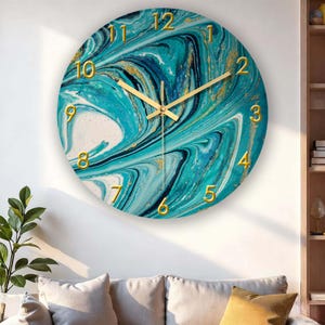 May include: Round wall clock with a teal and white marbled design, accented with gold numerals and hands. The clock face has a swirling pattern, creating a modern and artistic look. The clock is a decorative item for home decor.