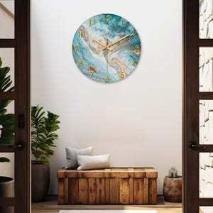 May include: A round wall clock with a blue and gold marble design. The clock has gold-colored numerals and hands. The clock is hanging on a white wall above a wooden bench.
